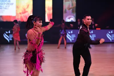 Dancesport competitor: Male dancer: black long-sleeved shirt with silver/white sequin accents on the sh