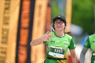 Marathon runner #5351: Runner 1: green jersey, black cap, glasses, black waist belt