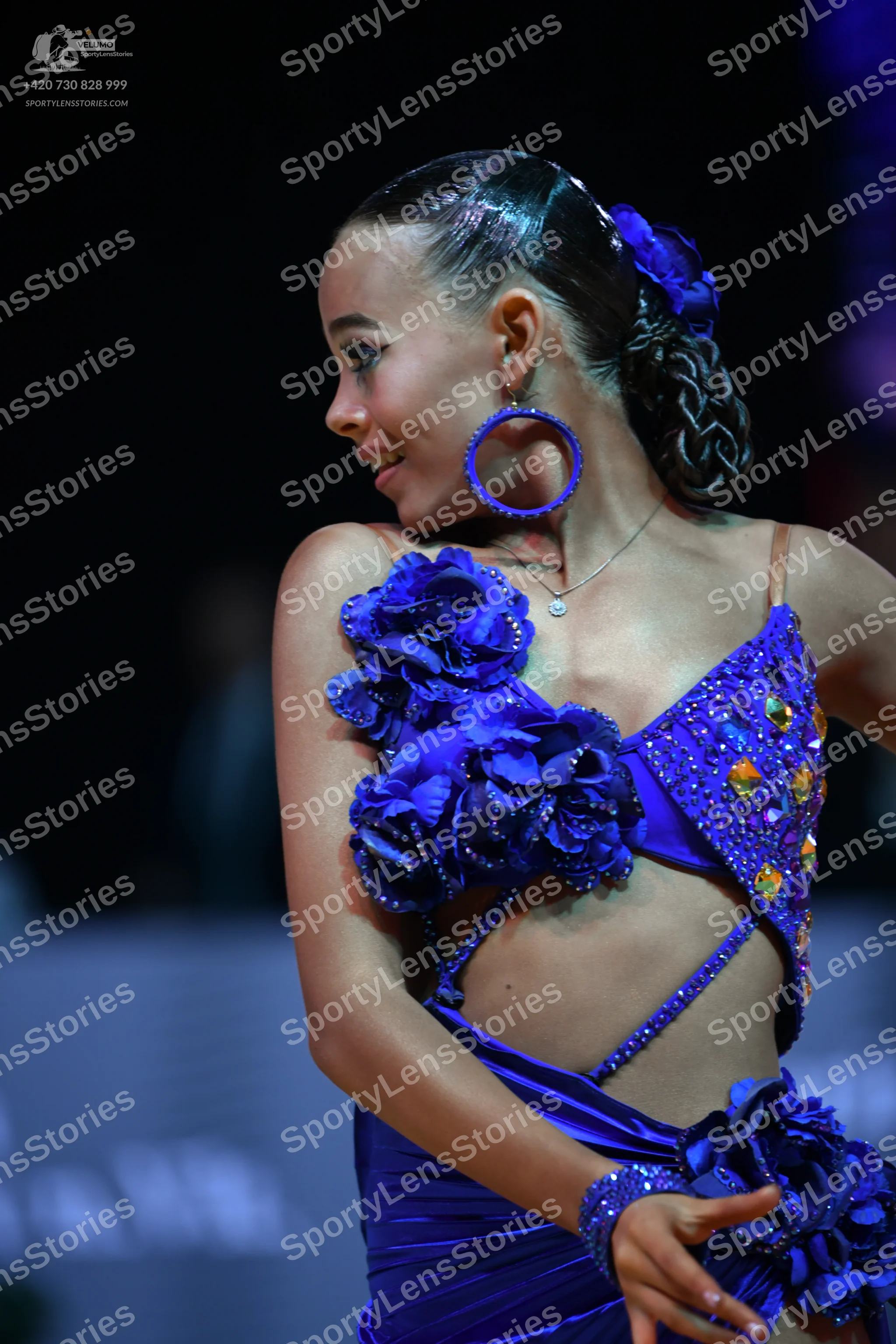 Dancesport competitor: Female dancer: blue Latin dress with satin-like fabric, featuring large 3D fabri