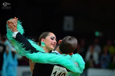 Dancesport competitor #140: Male dancer: black suit with a white shirt cuff visible