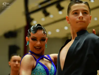 Dancesport competitor: Female dancer: teal sequined Latin dance top with blue straps and matching teal 