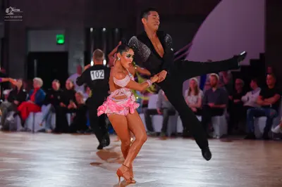 Dancesport competitor #102: Male dancer: black long-sleeved shirt with silver sequins on one side and black 