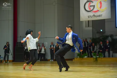 Dancesport competitor: Male dancer: blue patterned jacket, white shirt, black tie, and black trousers