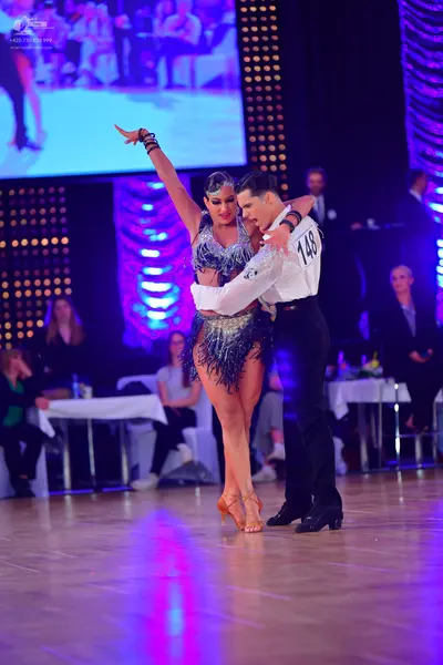 Dancesport competitor #148: Male dancer: white long-sleeved shirt with dark embellishments and black trouser