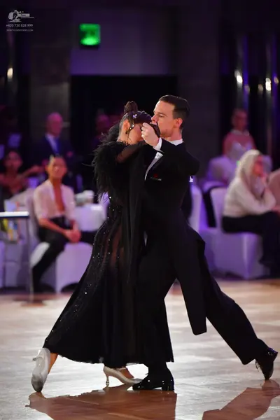 Dancesport competitor: Male dancer: black ballroom tailcoat with black trousers and black dance shoes