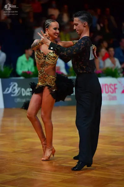 Dancesport competitor: Male dancer: black long-sleeved shirt with a dark patterned design and black tro
