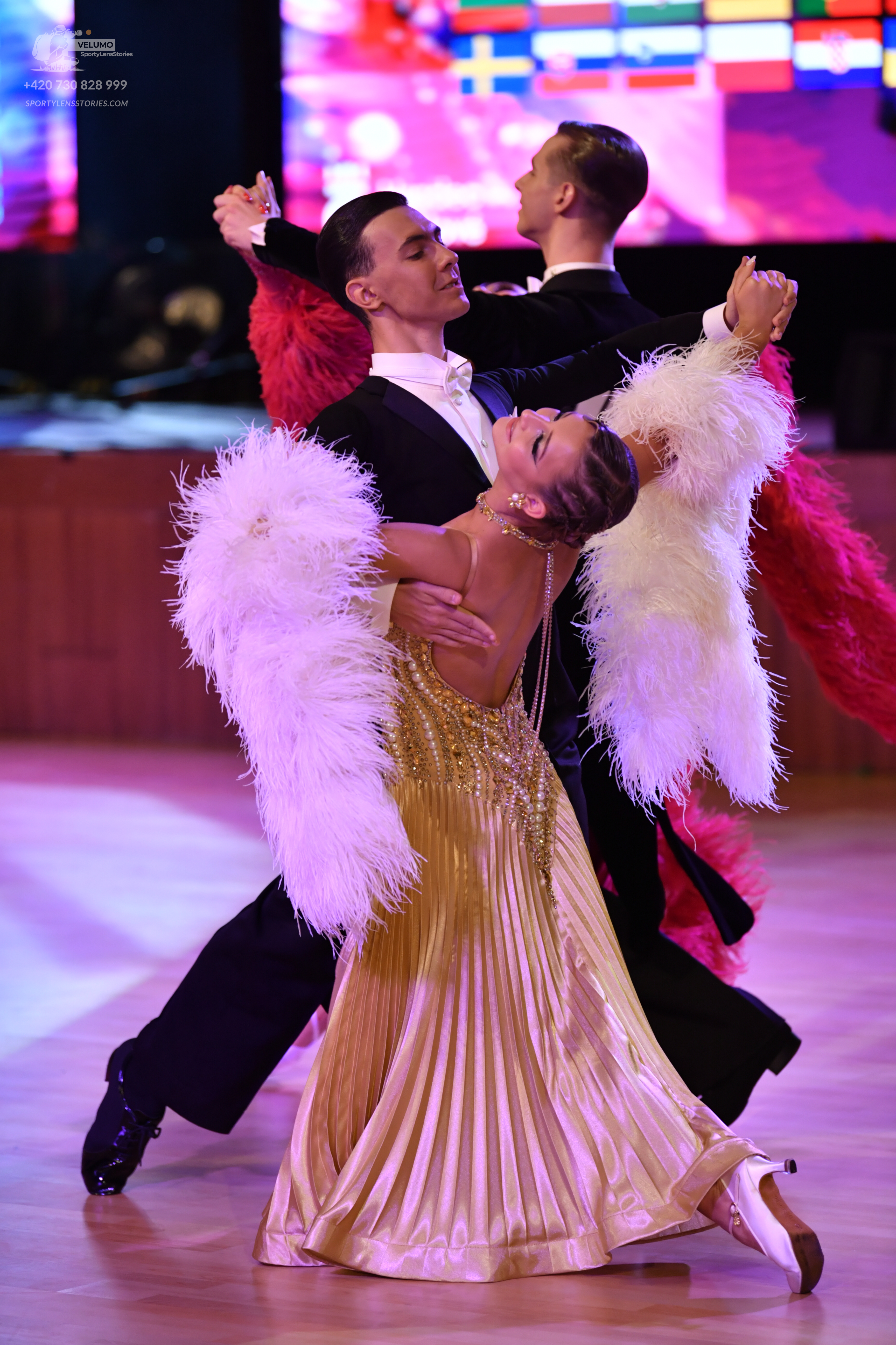 Dancesport competitor: Female dancer: gold satin-like ballgown with a sequin-embellished bodice, pleate