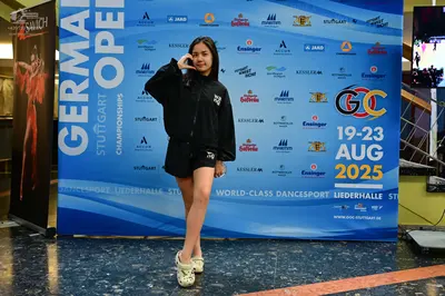 Dancesport competitor: Female dancer: black zip-up jacket and black shorts