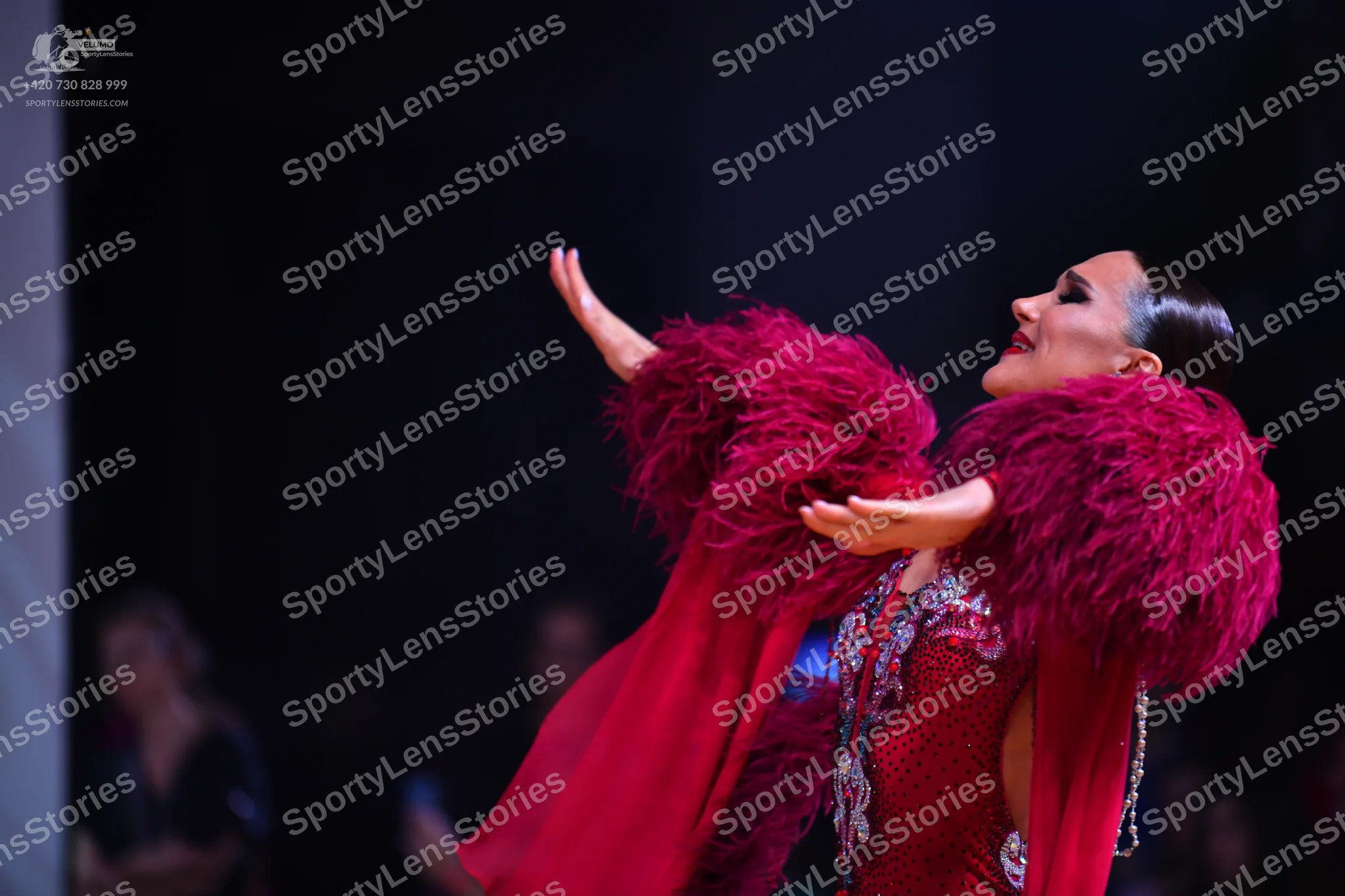 Dancesport competitor: Female dancer: deep red Latin dress with heavy sequin and crystal embellishments