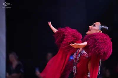 Dancesport competitor: Female dancer: deep red Latin dress with heavy sequin and crystal embellishments