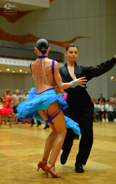 Dancesport competitor: Female dancer: bright blue and purple latin dance dress, backless, with a textur