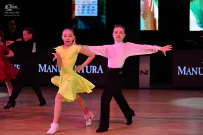 Dancesport competitor: Female dancer in foreground: yellow latin dress