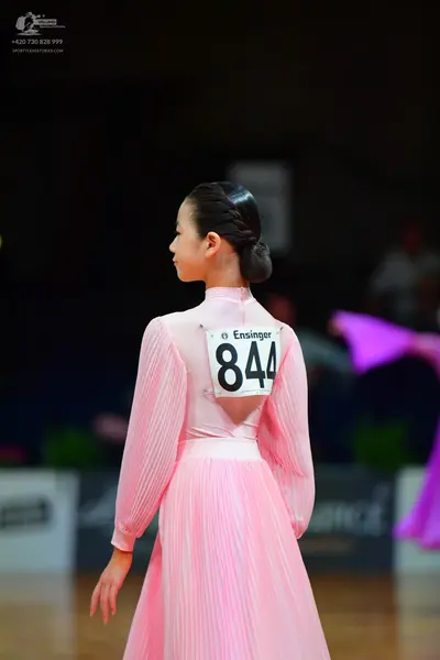 Dancesport competitor: Female dancer: light pink long-sleeved pleated gown