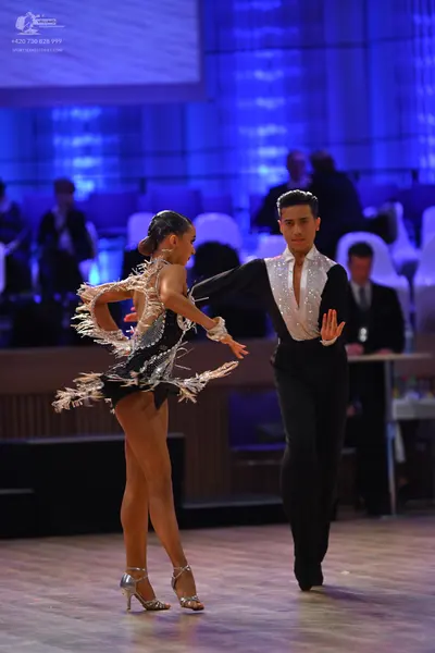 Dancesport competitor: Male dancer: black long-sleeved shirt with a white/silver sequined front panel a