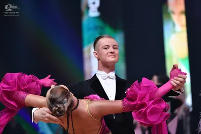 Dancesport competitor: Male dancer: black tuxedo with a white shirt and white bow tie