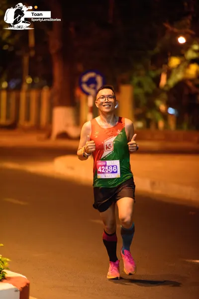 Marathon runner #42586: Runner 1: red, white, and green tank top, black shorts, pink shoes, blue socks, 