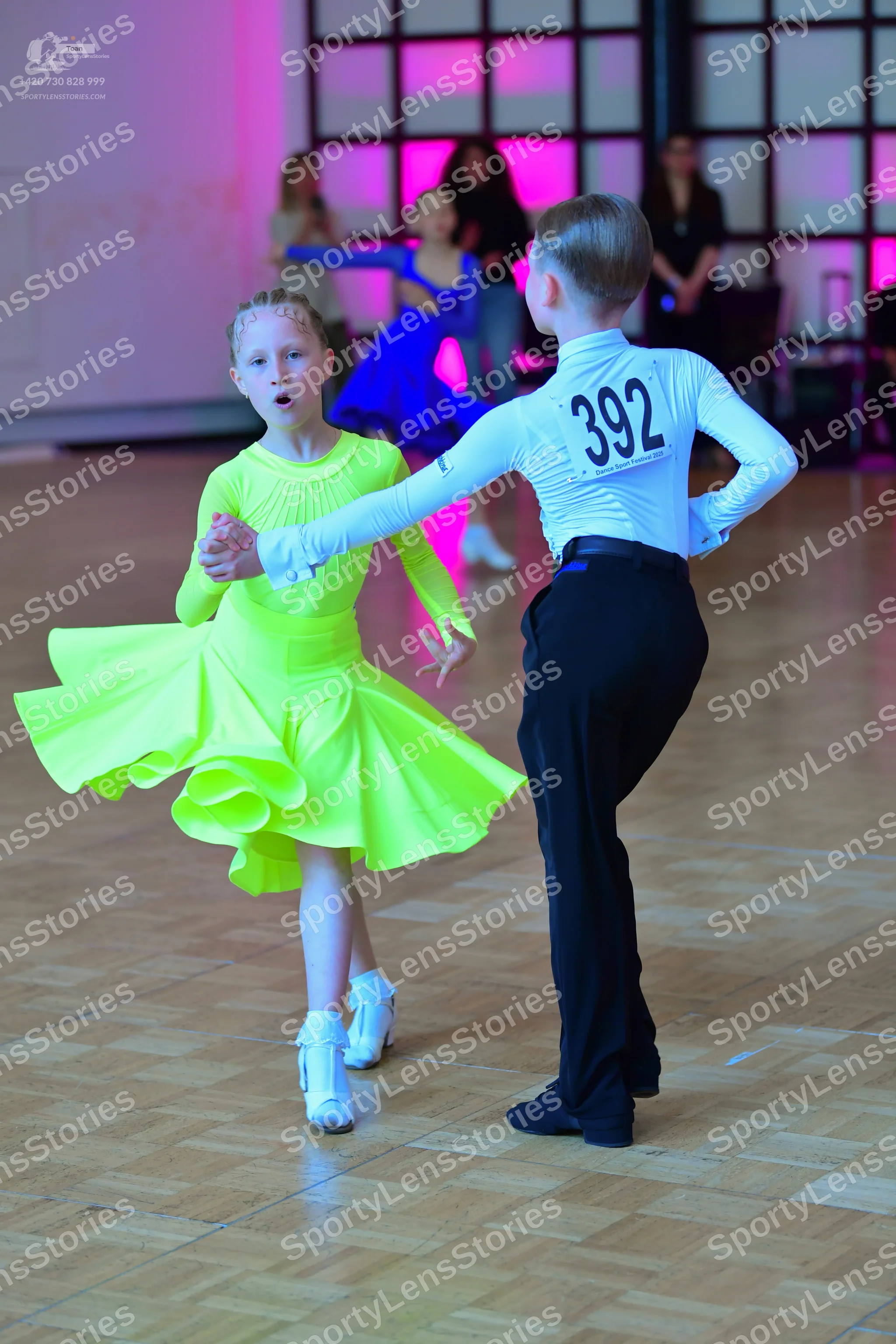 Dancesport competitor #392: Male dancer: white long-sleeved shirt with black number 392 and black trousers