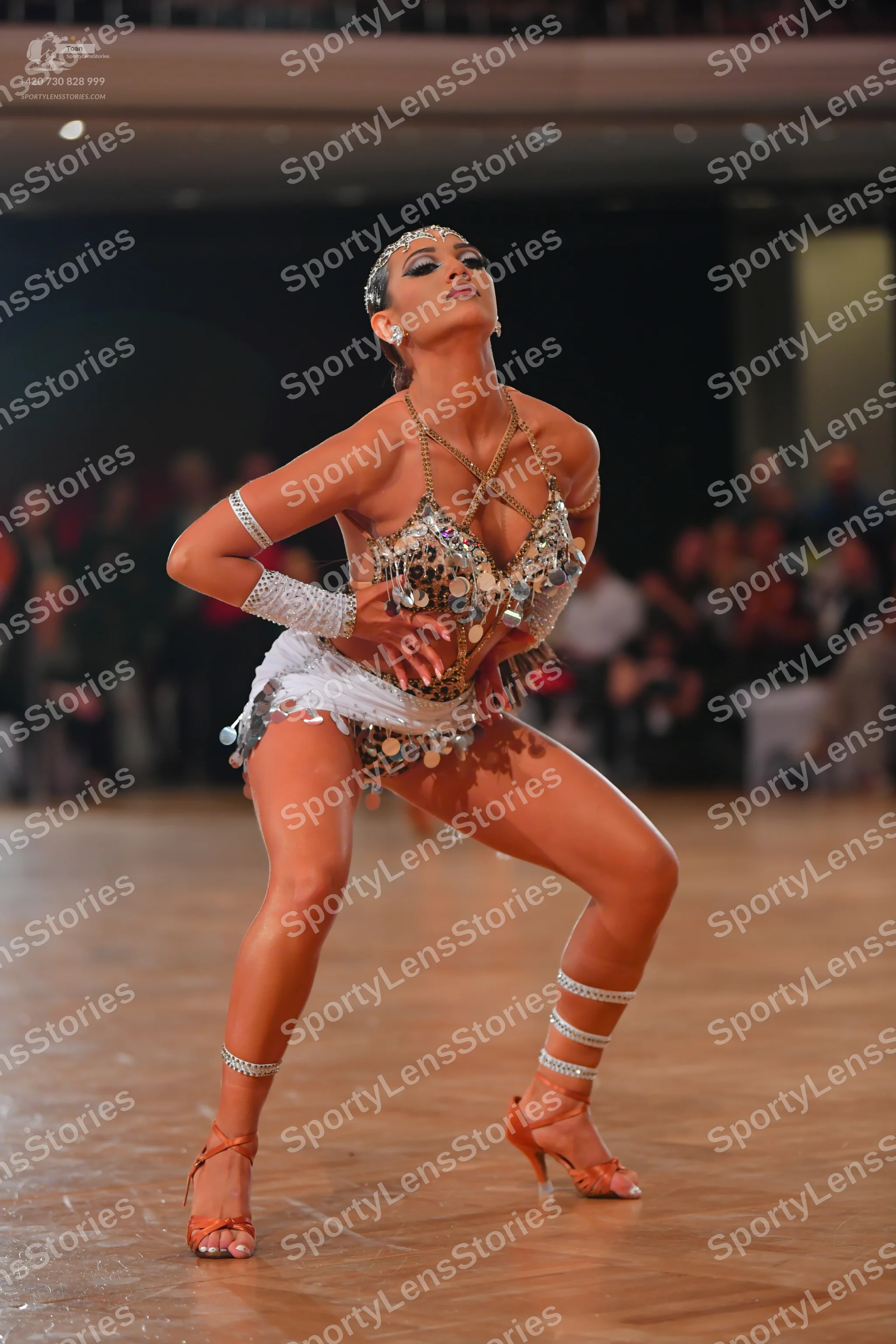 Dancesport competitor: Female dancer: silver and gold metallic Latin dance costume heavily embellished