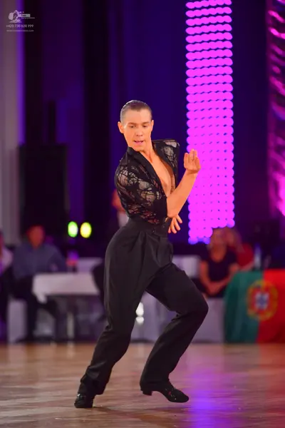 Dancesport competitor: Male dancer: black Latin dance top with lace pattern and black trousers