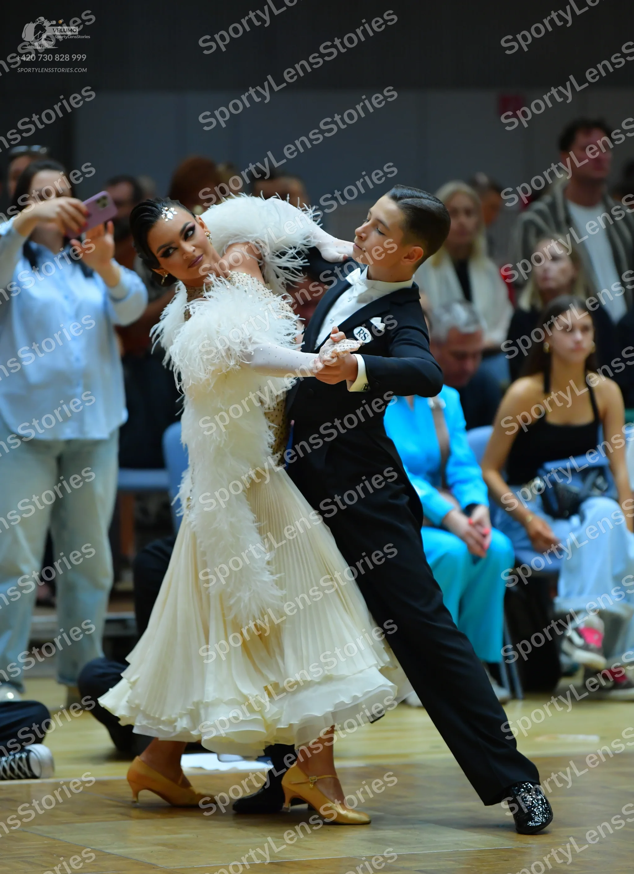 Dancesport competitor: Female dancer: white ballroom dress with large feather trim on the bodice and sh