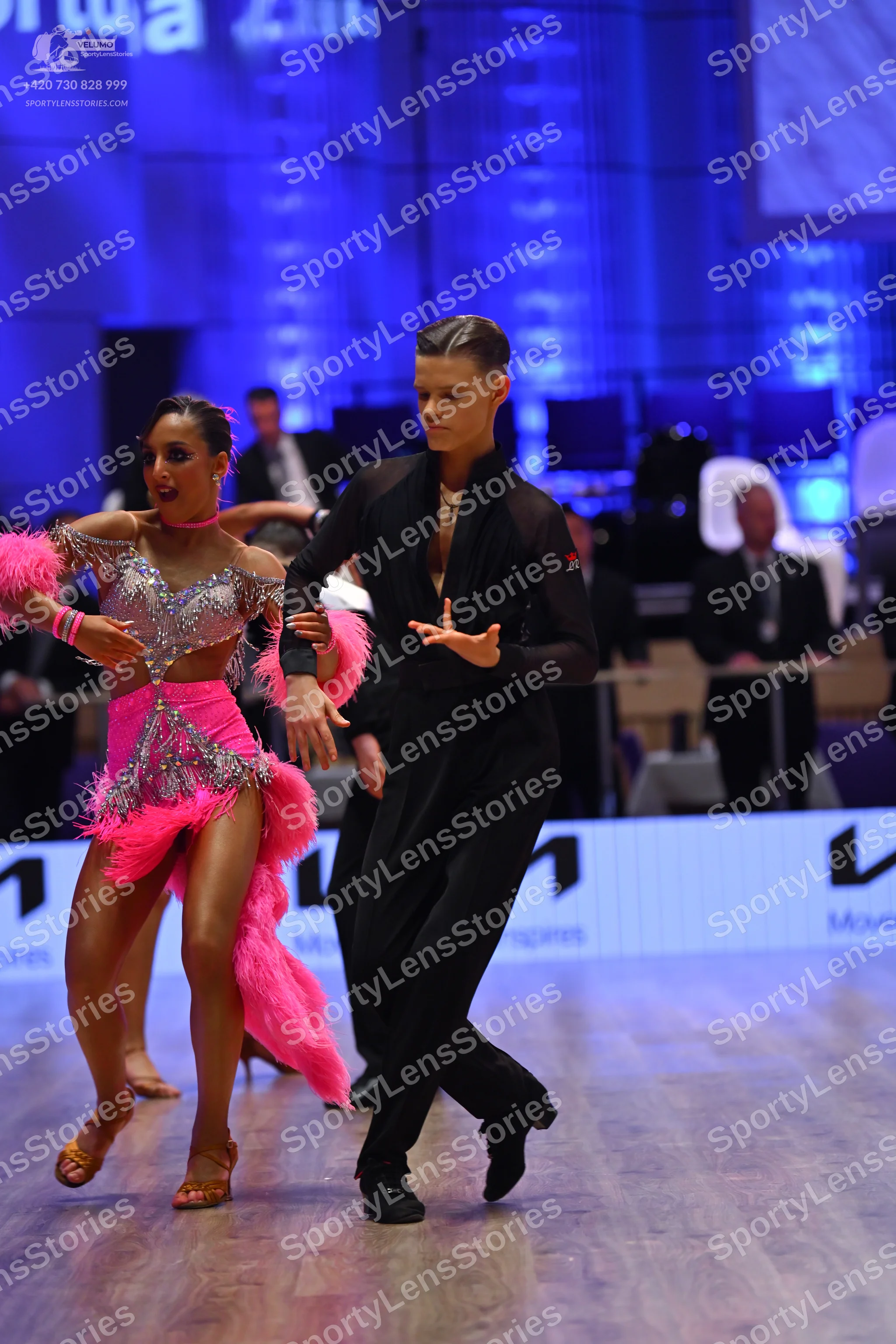 Dancesport competitor: Female dancer: pink Latin dress with silver sequins and long pink feather/fringe