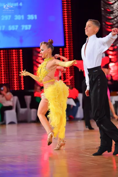 Dancesport competitor: Female dancer: bright yellow Latin dance costume with a sequined top, a skirt fe