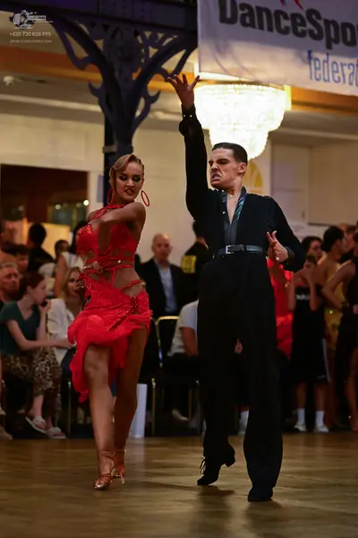 Dancesport competitor: Female dancer: red latin dress with cutouts and a ruffled skirt