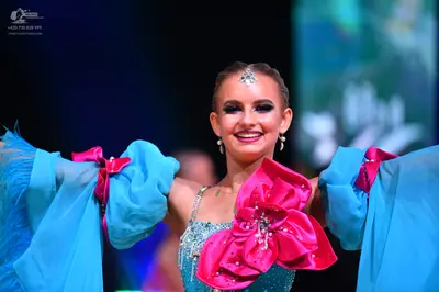 Dancesport competitor: Female dancer: light blue sequined bodice with large, flowing light blue sleeves