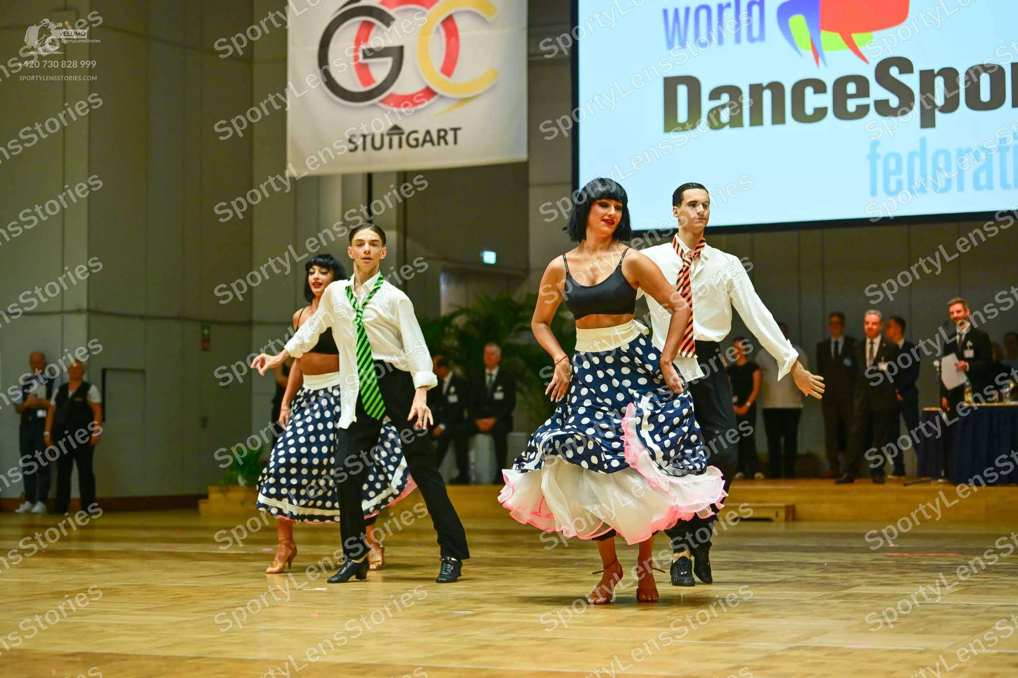 Dancesport competitor: Male dancer 1: white long-sleeved shirt, green patterned necktie, black trousers