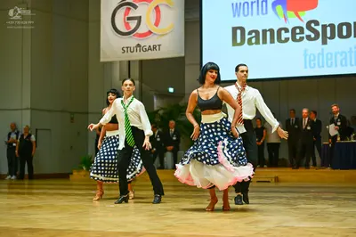 Dancesport competitor: Male dancer 1: white long-sleeved shirt, green patterned necktie, black trousers