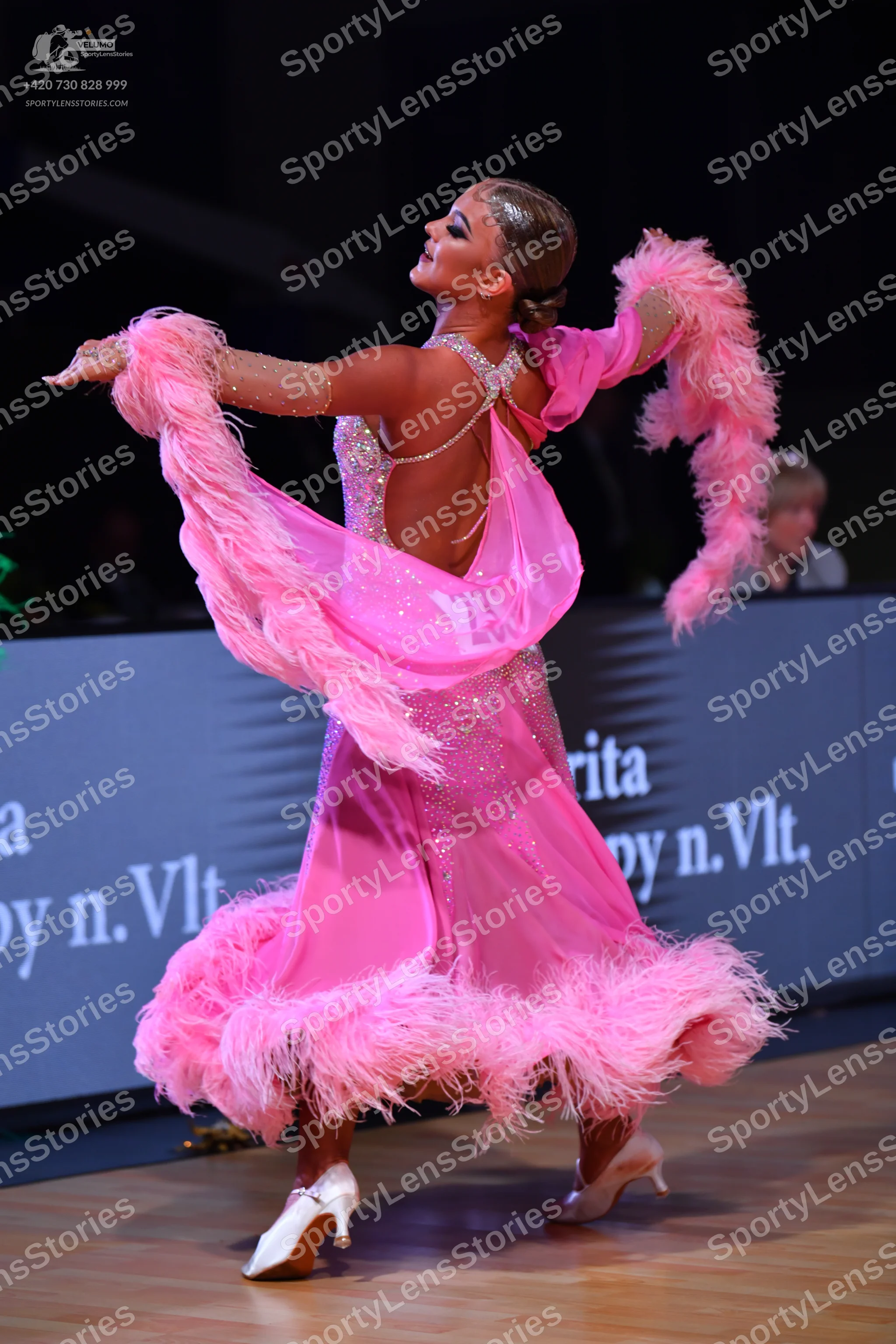 Dancesport competitor: Female dancer: pink Latin dress with sparkling stones/sequins, featuring large p