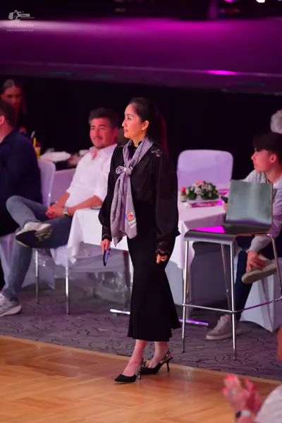 Dancesport competitor: Female dancer: black long-sleeved, midi-length dress with a grey scarf and black