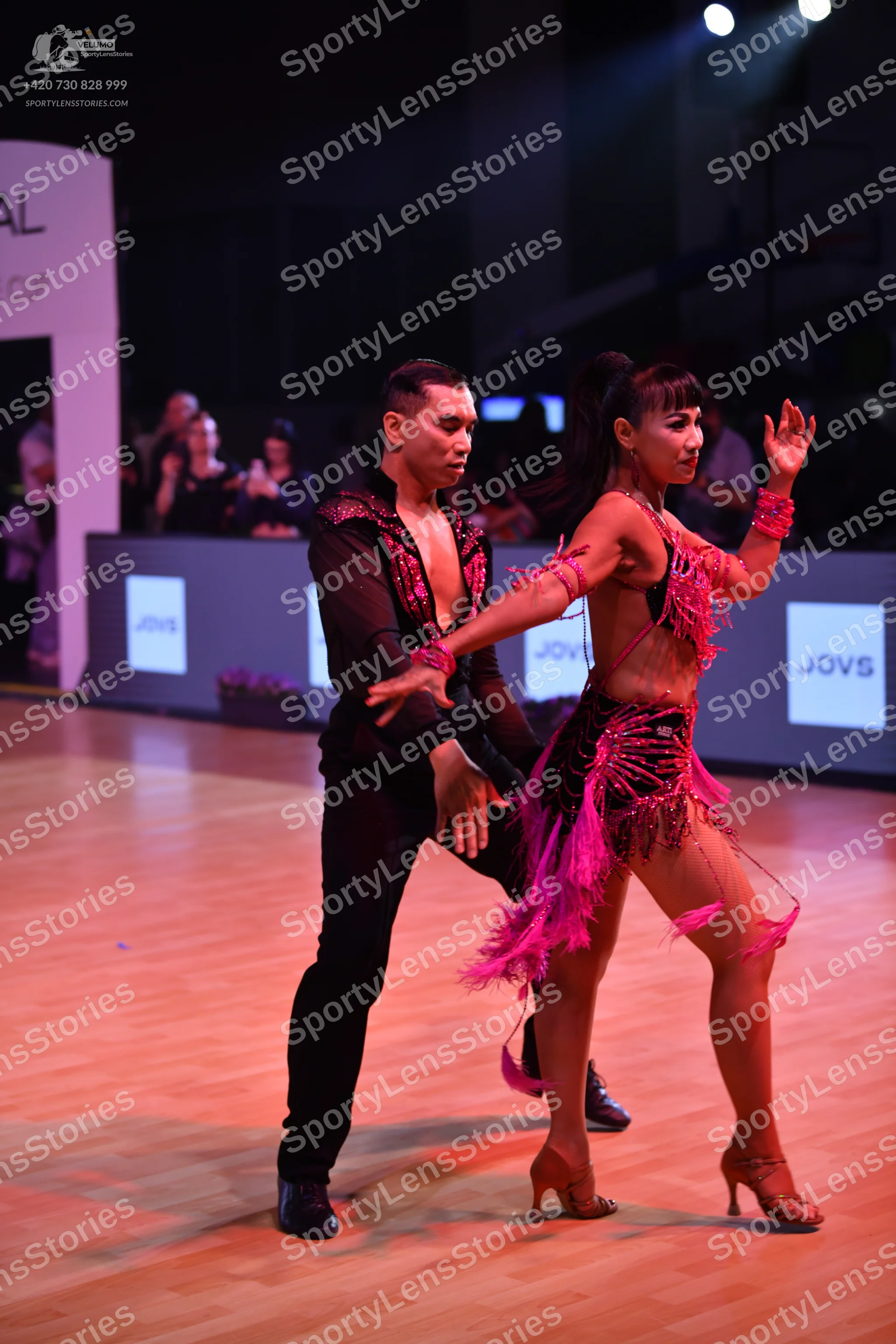 Dancesport competitor: Male dancer: black latin dance shirt with pink/red sequin embellishments and bla