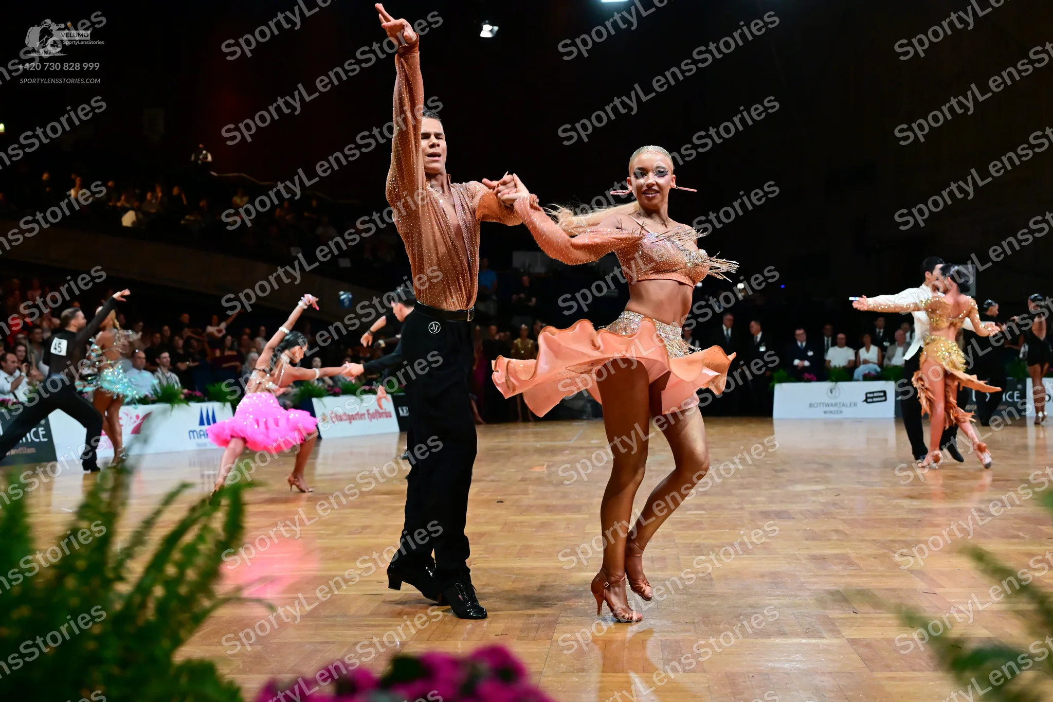 Dancesport competitor: Male dancer in foreground: peach-colored long-sleeve shirt with subtle texture a
