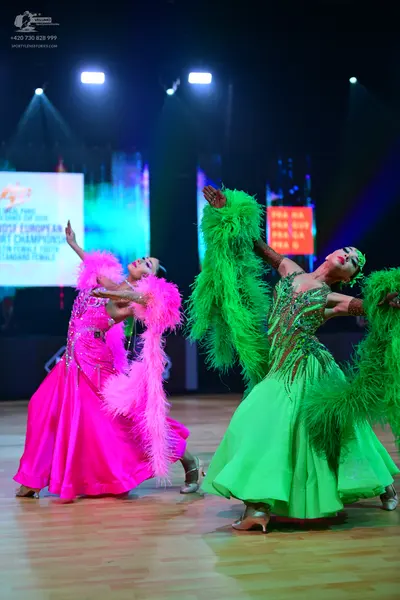 Dancesport competitor: Female dancer 1: bright pink ballgown with a large, fluffy pink feather boa arou