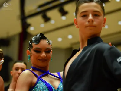Dancesport competitor: Female dancer: bright blue Latin dance dress with teal sequins and thin straps, 