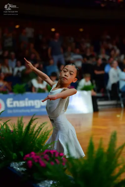 Dancesport competitor: Female dancer: white dance dress with a mesh top and a flared skirt