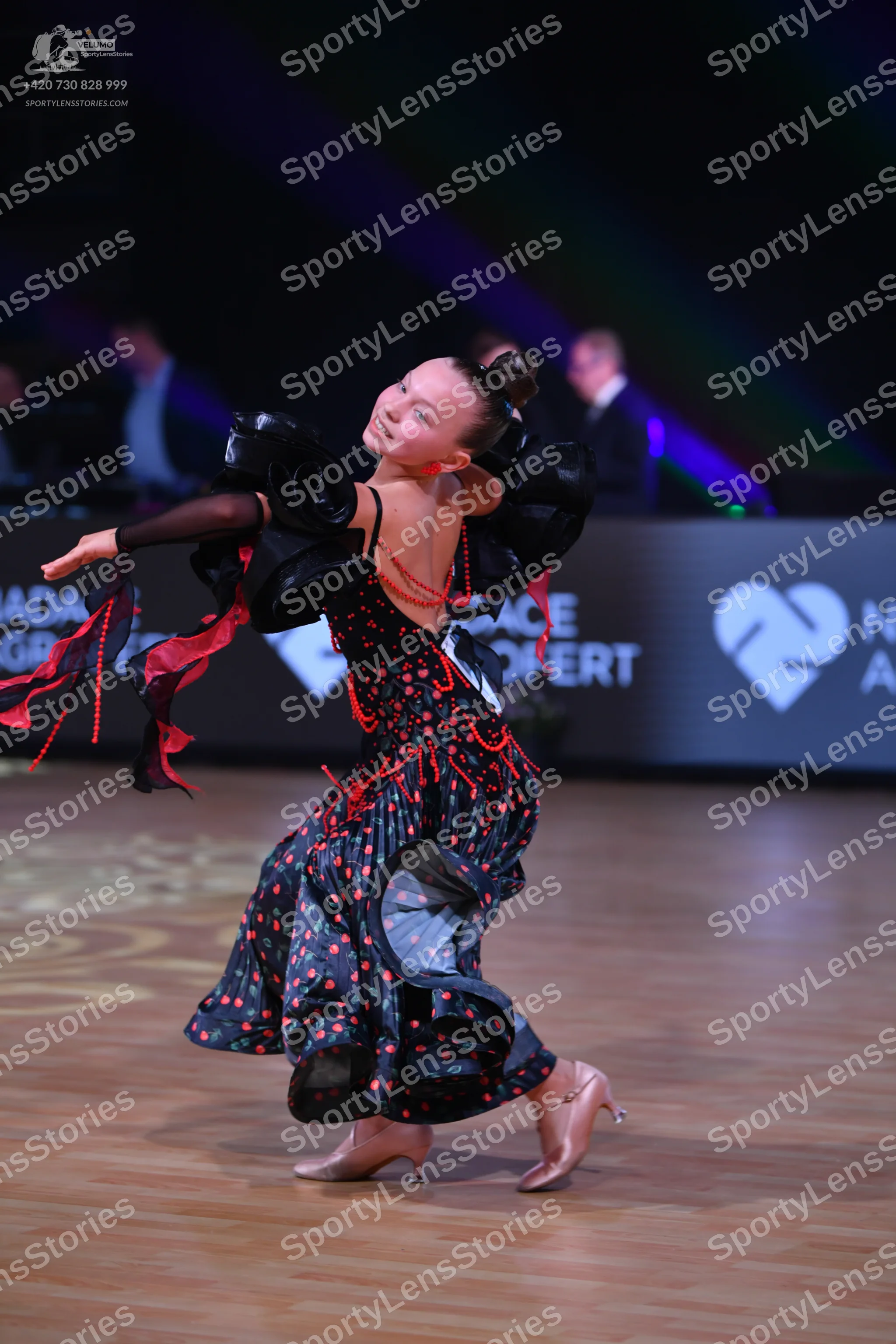 Dancesport competitor: Female dancer: Black Latin dance dress featuring red sequin/bead embellishments