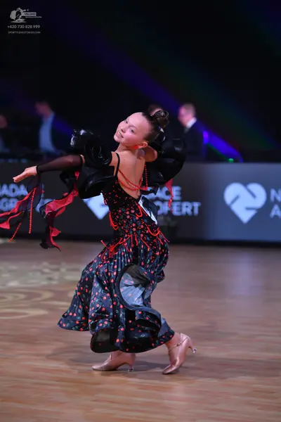 Dancesport competitor: Female dancer: Black Latin dance dress featuring red sequin/bead embellishments 