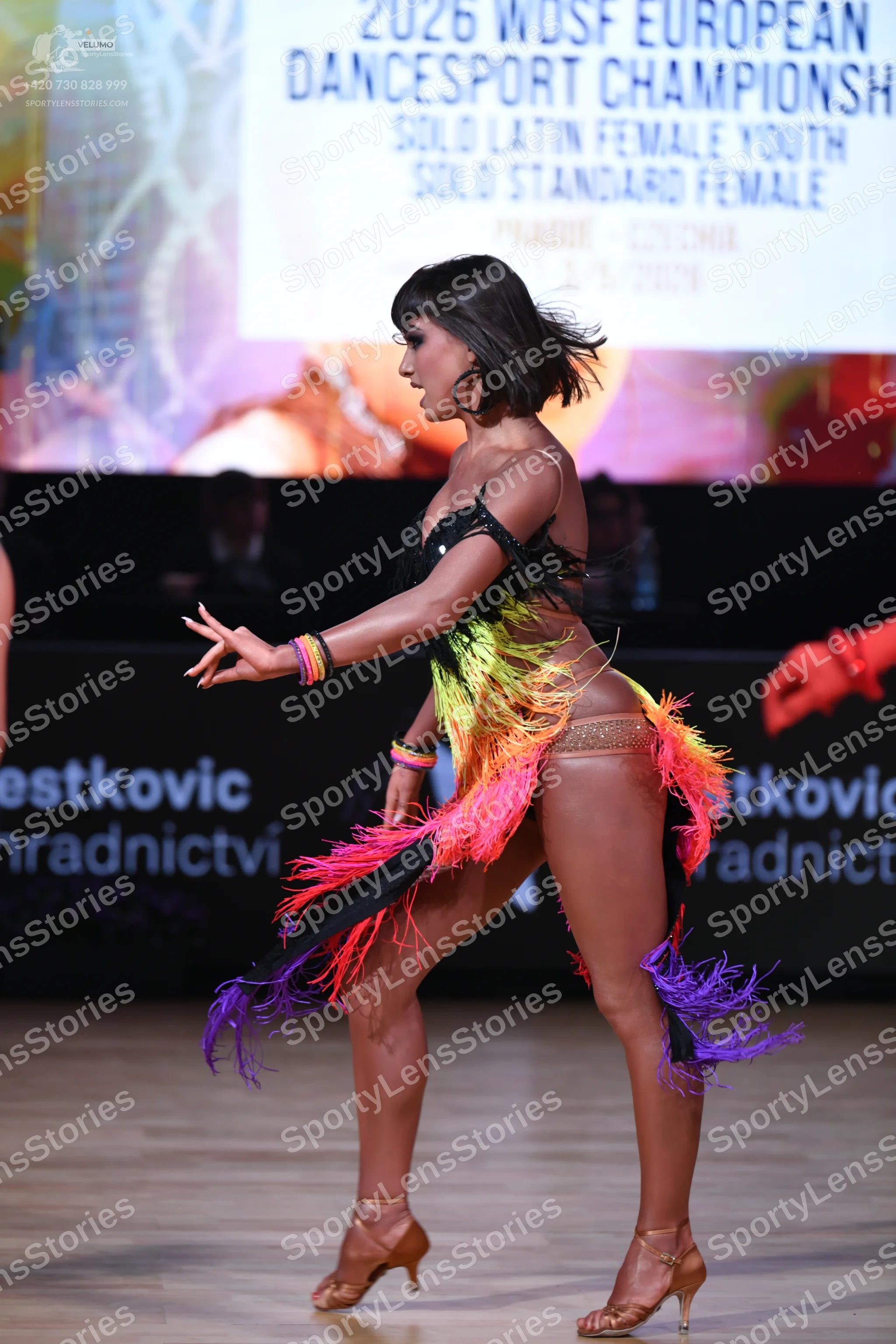 Dancesport competitor: Female dancer: multicolored Latin dress with a black bodice and gradient-colored