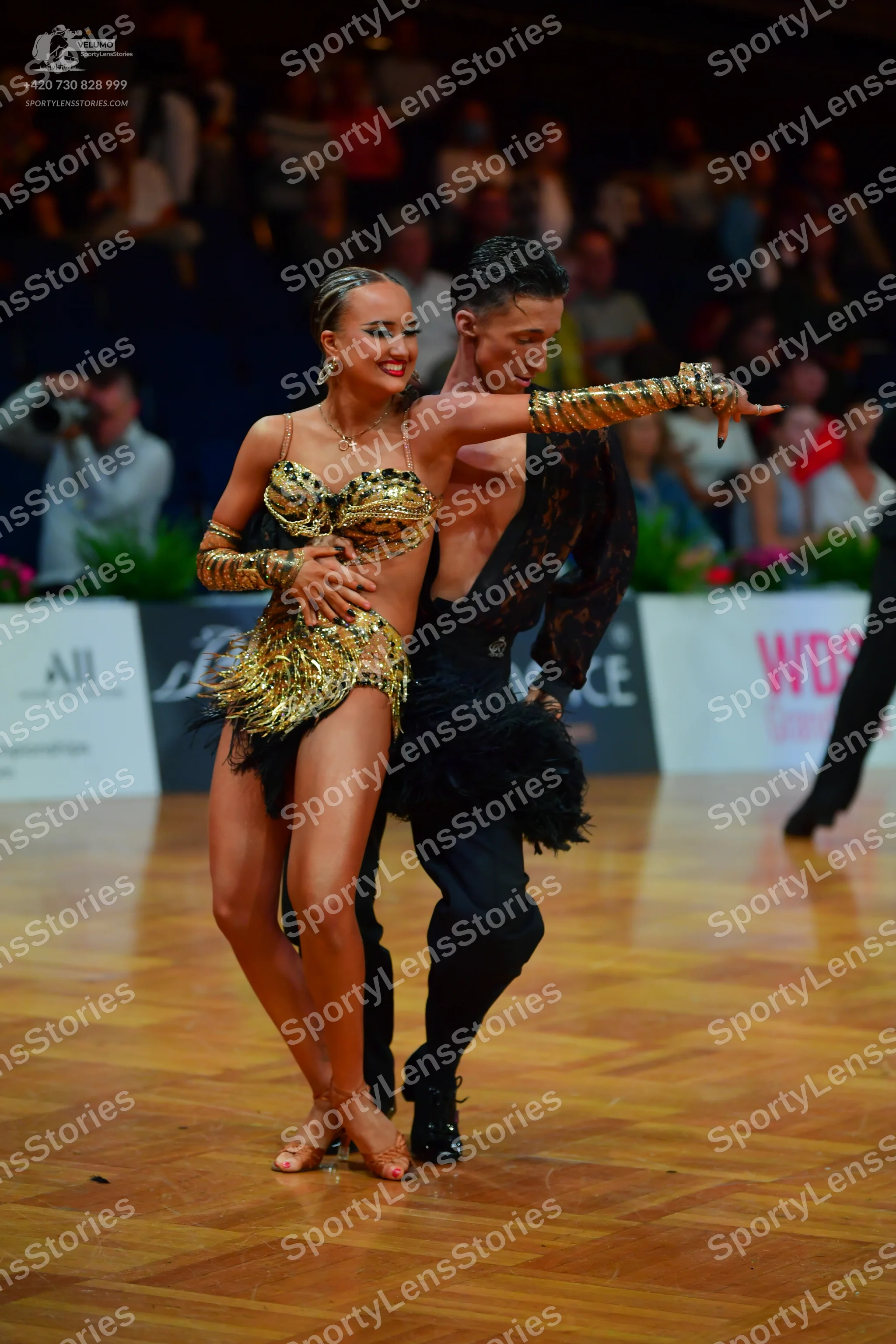 Dancesport competitor: Female dancer: gold sequined latin dance outfit with a two-piece style, featurin