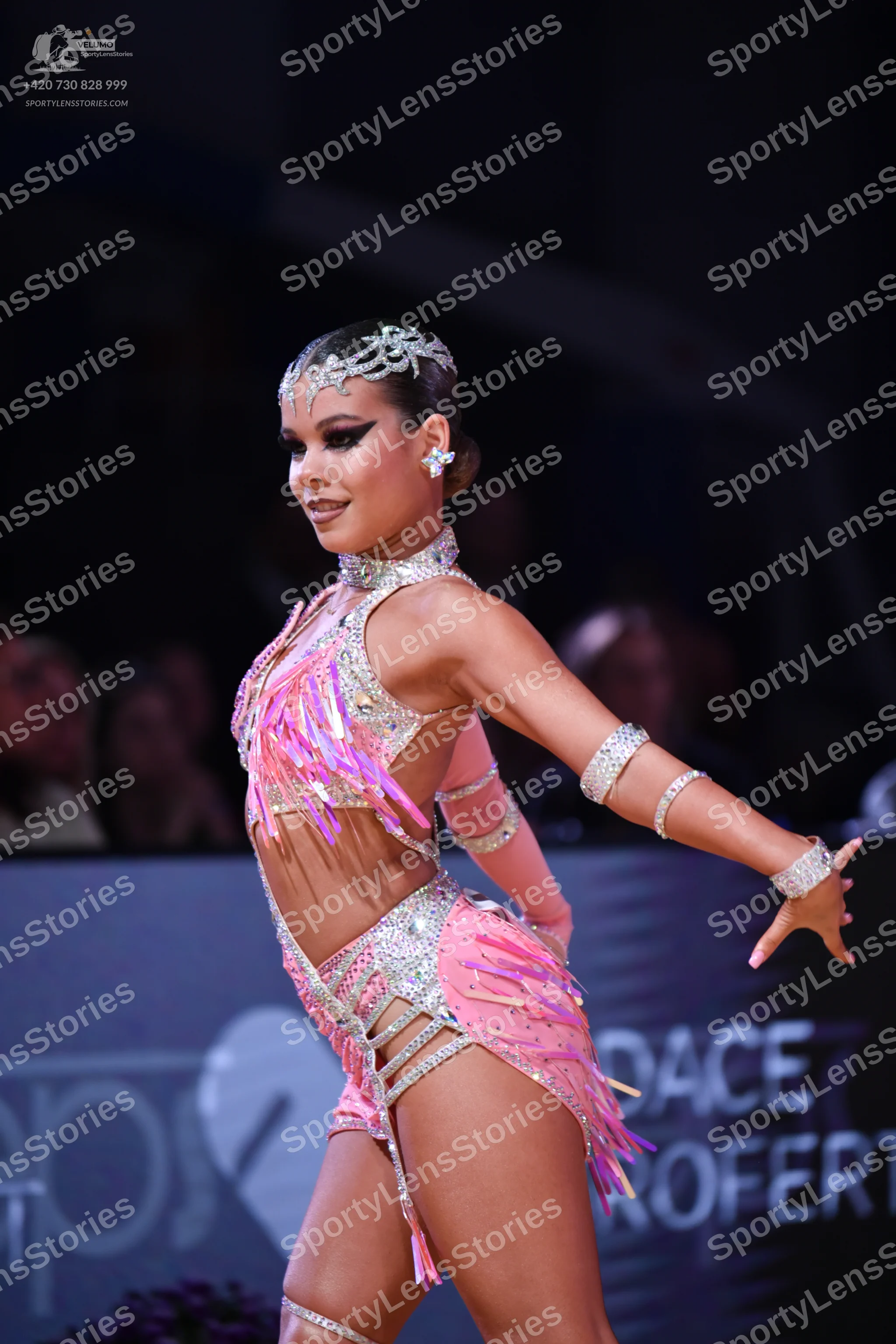 Dancesport competitor: Female dancer: pink latin costume with sequins, rhinestones, and pink fringe, in