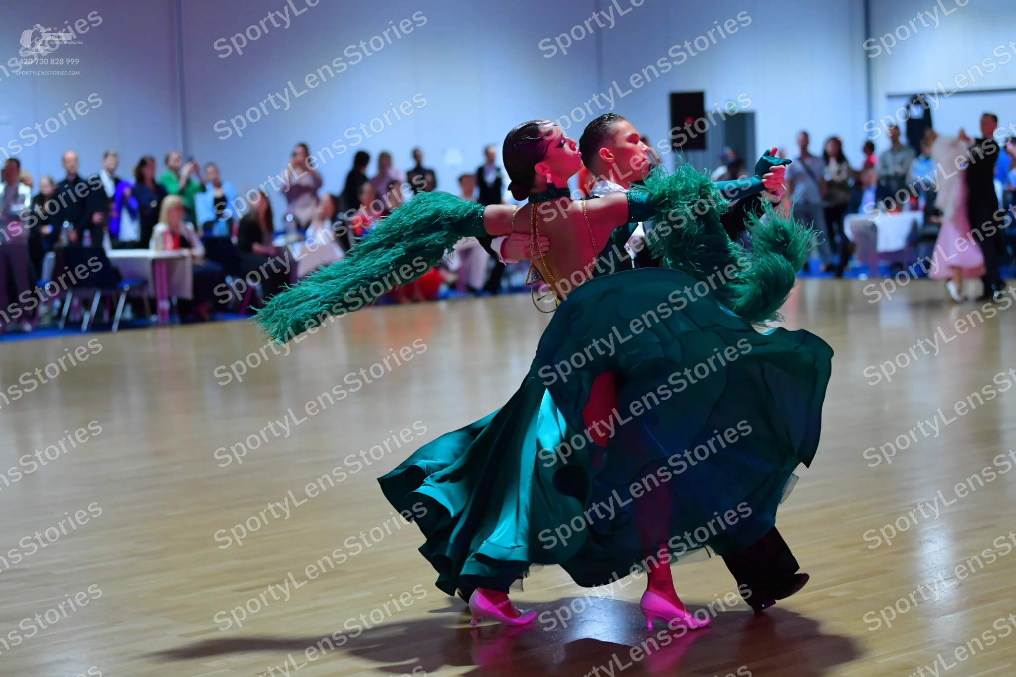 Dancesport competitor: Female dancer: Emerald green ballgown with a voluminous, flowing skirt and large