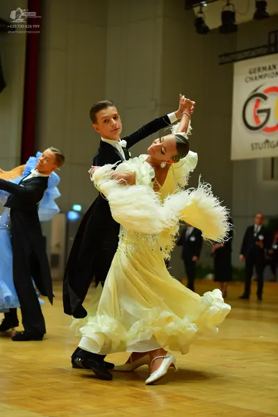 Dancesport competitor: Male dancer: black long-sleeved shirt with white collar and black trousers