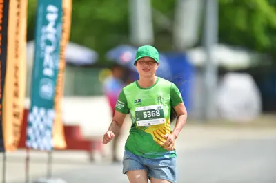 Marathon runner #5368: Runner 1: green jersey, light blue shorts, green cap
