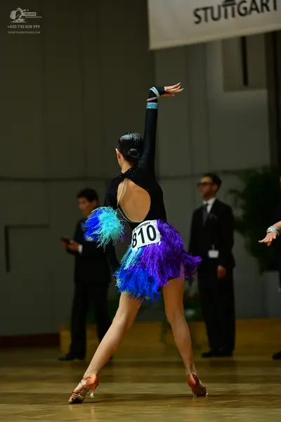 Dancesport competitor #810: Female dancer: black Latin dress with an open back and a vibrant blue and purple