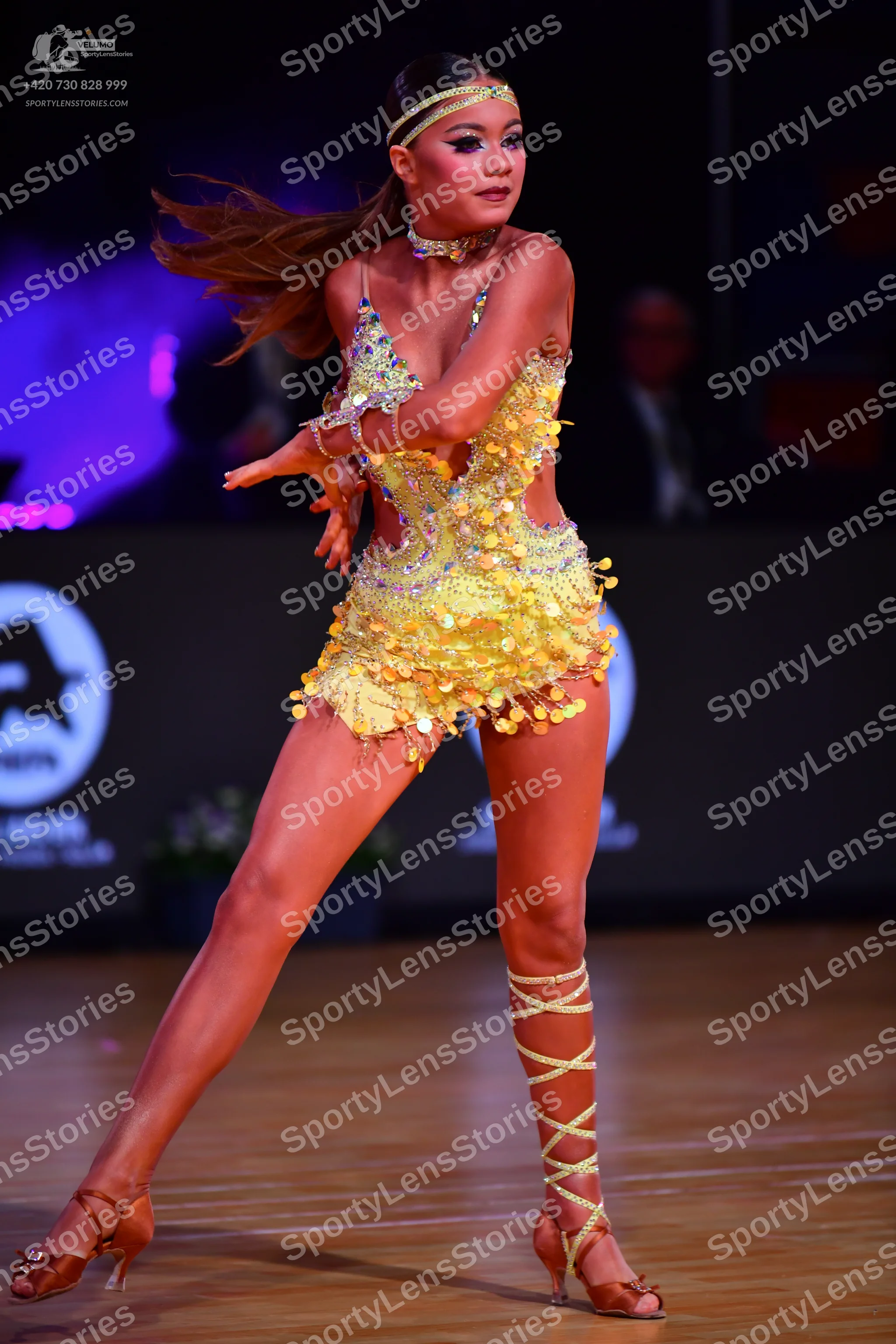 Dancesport competitor: Female dancer: bright yellow Latin dance costume heavily embellished with sequin