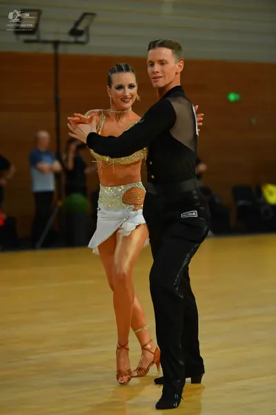Dancesport competitor: Male dancer: black long-sleeve shirt with sheer mesh panels and black trousers