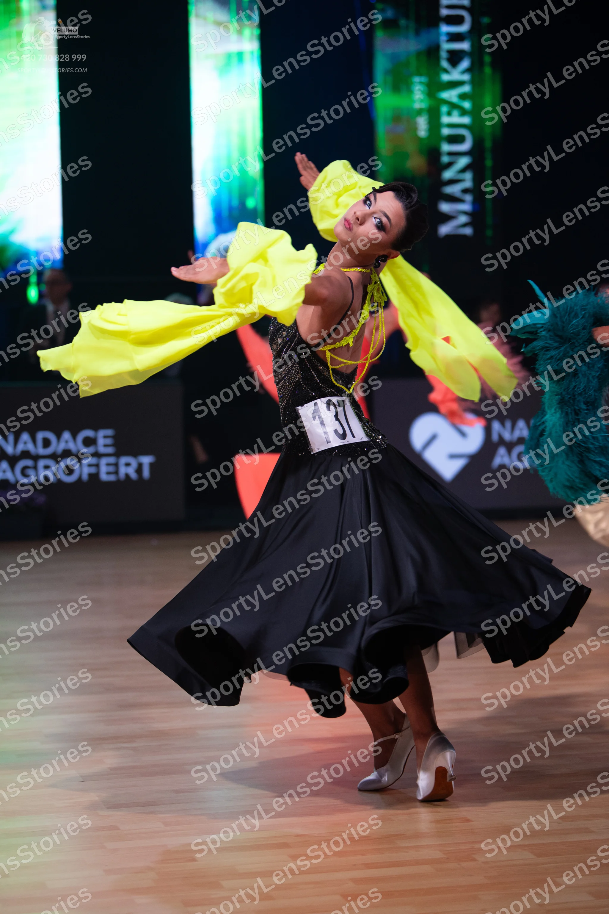 Dancesport competitor: Female dancer: black ballroom dress with a sequined bodice and a large, flowing
