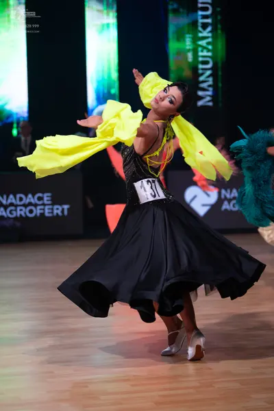 Dancesport competitor: Female dancer: black ballroom dress with a sequined bodice and a large, flowing 